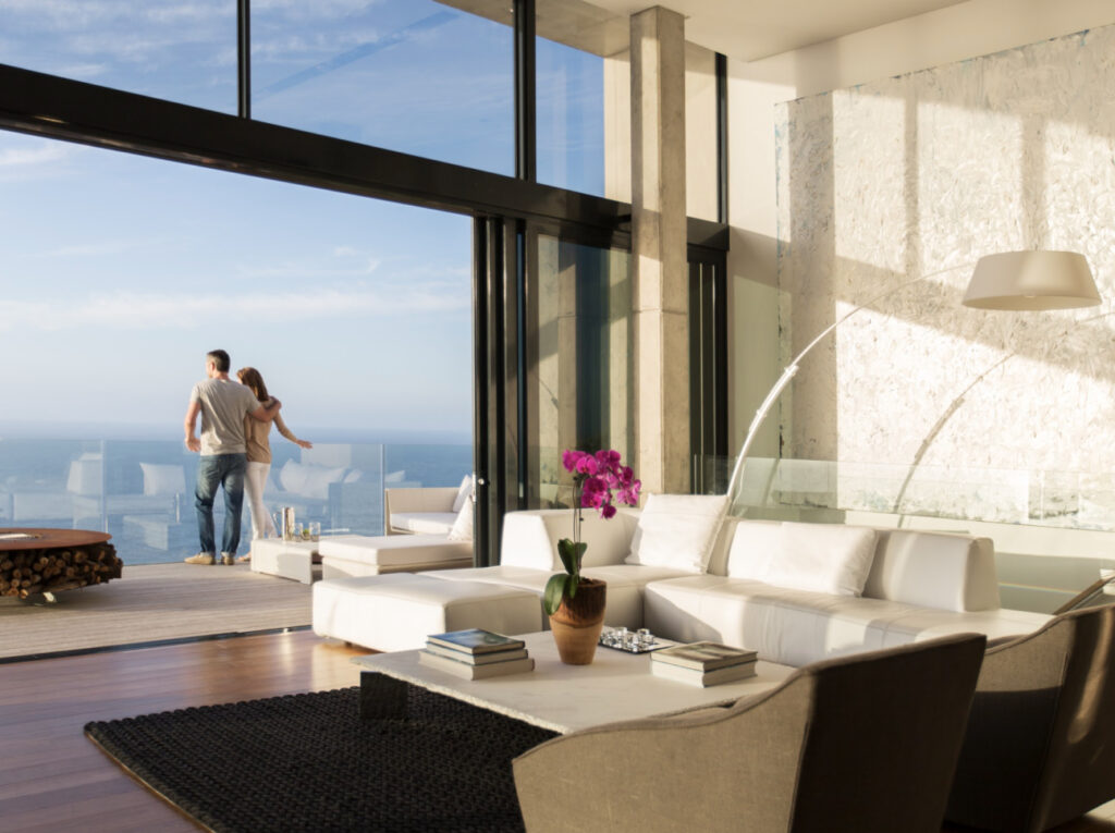 Couple standing on the balcony of a modern house.