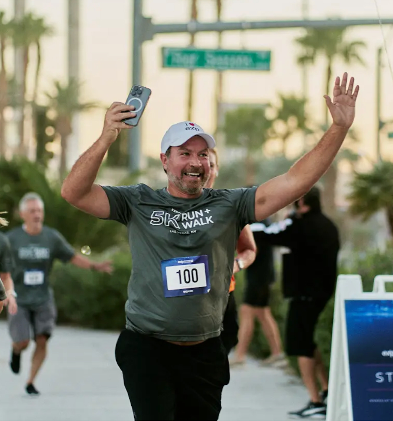 Man raising his arms in victory as he crosses the marathon finish line.