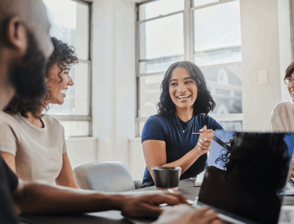 Personnes travaillant joyeusement dans une salle de réunion.