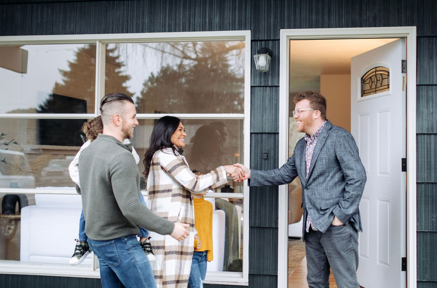 Agent immobilier rencontrant une famille en tant qu’acheteurs potentiels.